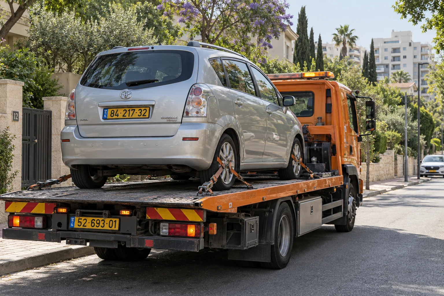 גרירת רכב בהוד השרון עם רכב מקובע על משטח גרר כתום